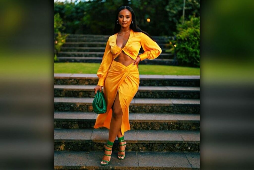 Kayla nicole wearing yellow dress holding green bag in hand