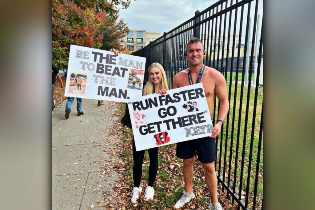 Sam and his girlfriend, Jess holding Posters