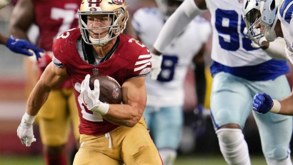 Christian McCaffrey running Holding football