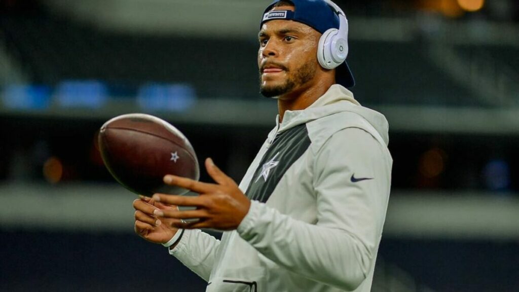 Dak Prescott has a ball in hand and listening to music while practicing