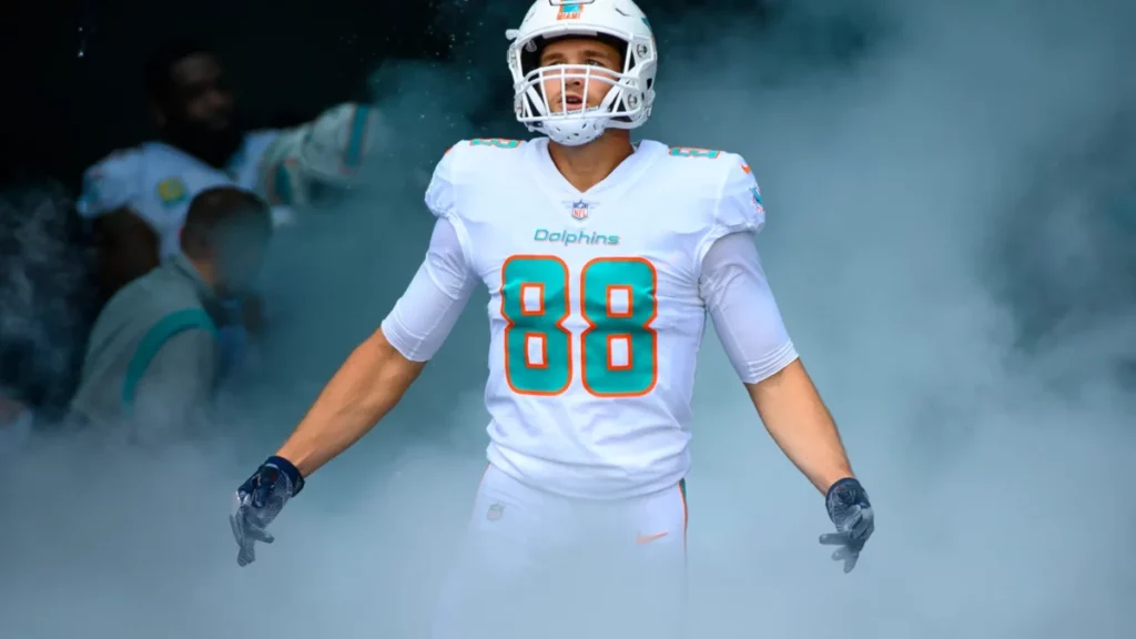 Miami Dolphins tight end Mike Gesicki (Jersey number 88) gestures as he runs onto the field