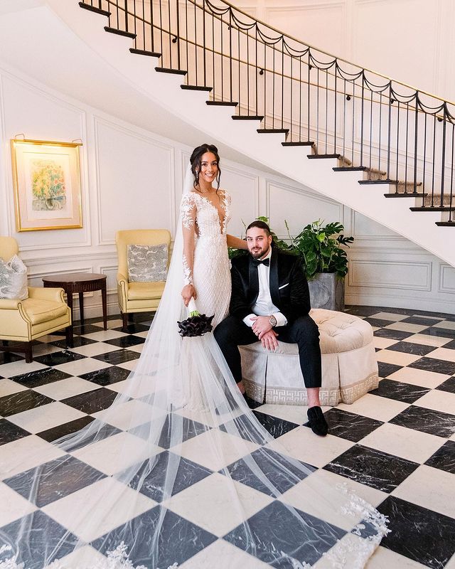 A bride and groom posing in front of a staircase