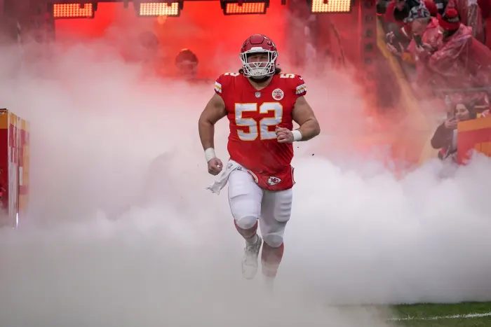 Kansas Chiefs player running through smoke at the Super Bowl.